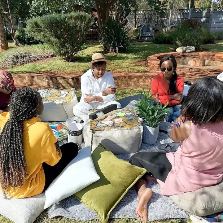 Women sit closely together outdoors for a reflective conversation.