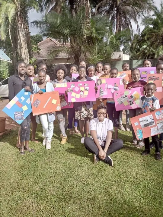 Young people hold colourful vision boards outdoors