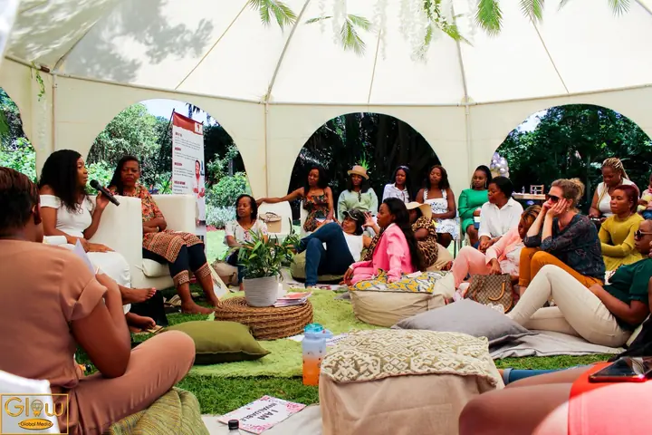 Women seated under a marquee during a facilitated discussion.